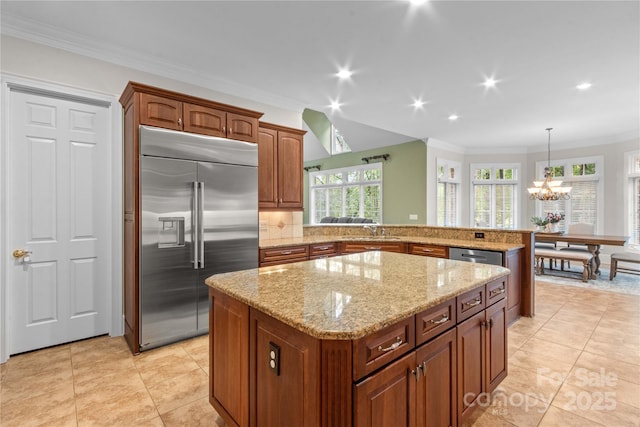 kitchen with light stone countertops, a kitchen island, a peninsula, appliances with stainless steel finishes, and crown molding