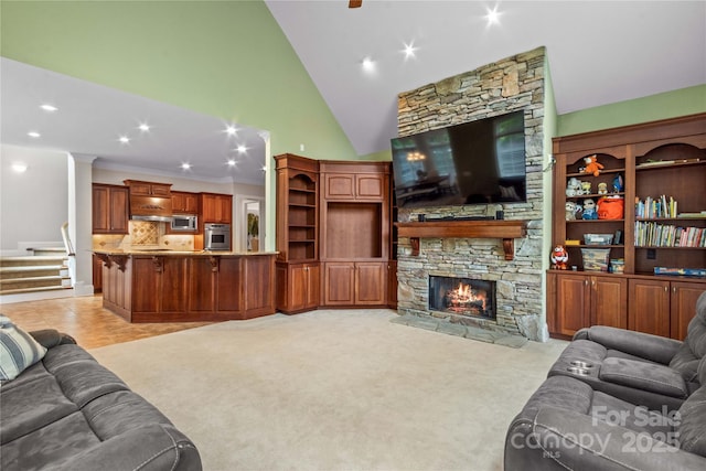 living area featuring light colored carpet, stairs, a stone fireplace, recessed lighting, and high vaulted ceiling