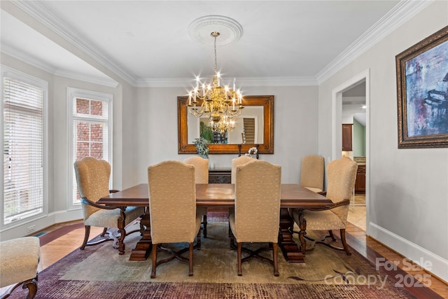 dining room featuring ornamental molding, wood finished floors, baseboards, and a chandelier