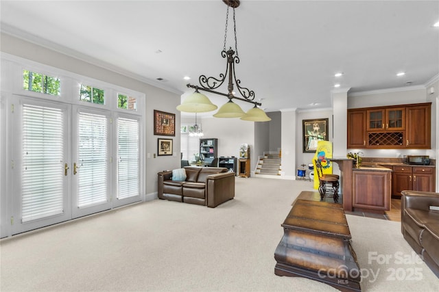 living area with stairway, carpet flooring, and ornamental molding