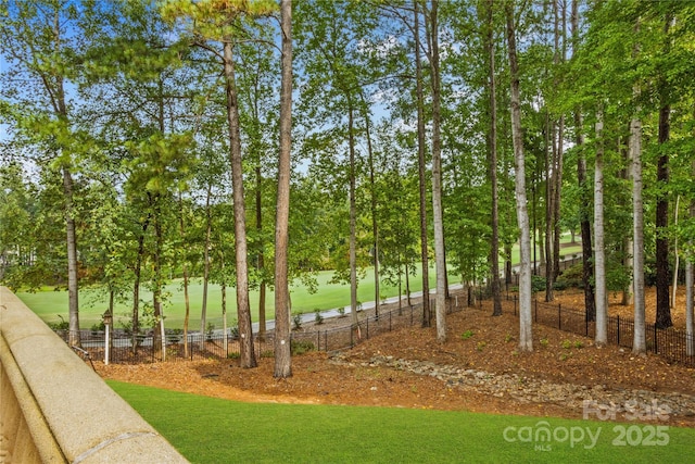 view of community with a lawn and fence