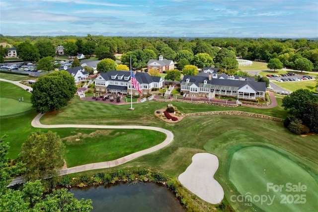 drone / aerial view with a wooded view and golf course view