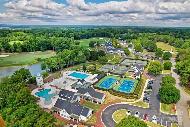 drone / aerial view featuring golf course view, a forest view, and a water view