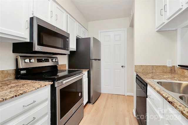 kitchen with appliances with stainless steel finishes, light stone countertops, light hardwood / wood-style flooring, and white cabinets