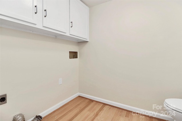 clothes washing area featuring hookup for a washing machine, hookup for an electric dryer, light hardwood / wood-style flooring, and cabinets