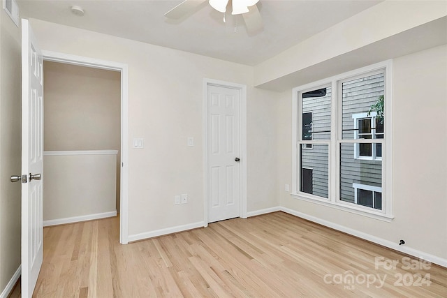 unfurnished bedroom featuring ceiling fan, a closet, and light hardwood / wood-style floors