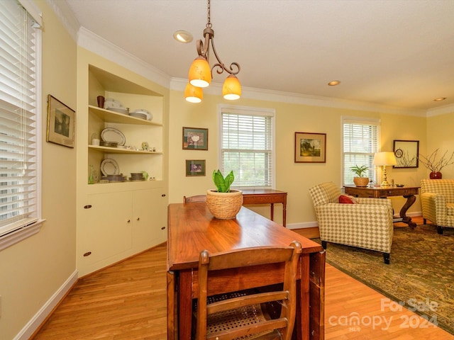 dining space featuring crown molding, a healthy amount of sunlight, and light wood-type flooring