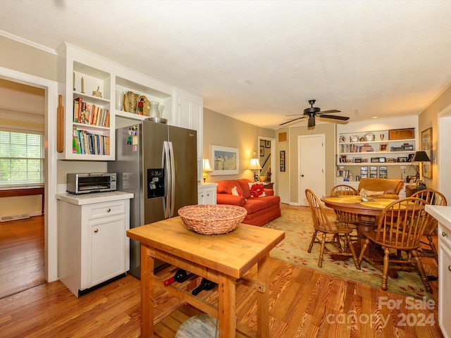 kitchen with ceiling fan, crown molding, light hardwood / wood-style flooring, white cabinets, and stainless steel fridge with ice dispenser