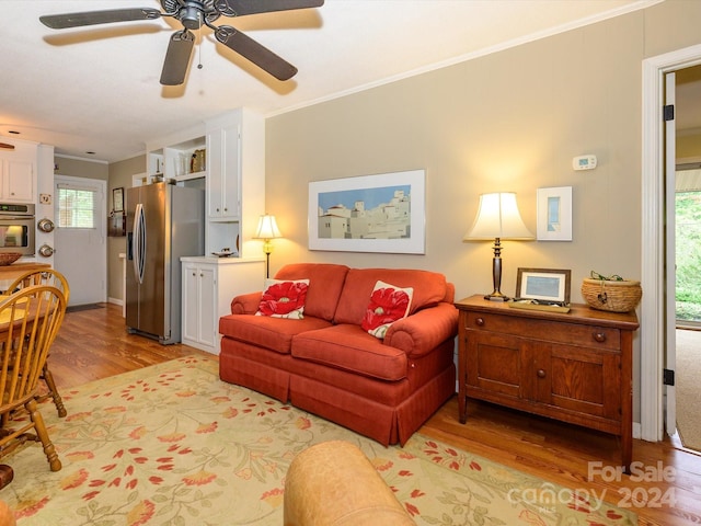 living room featuring crown molding, light hardwood / wood-style flooring, and ceiling fan