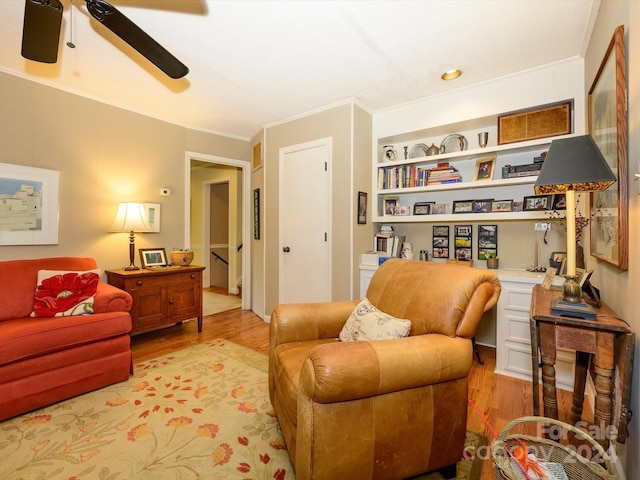 living area featuring ceiling fan, ornamental molding, and light hardwood / wood-style flooring