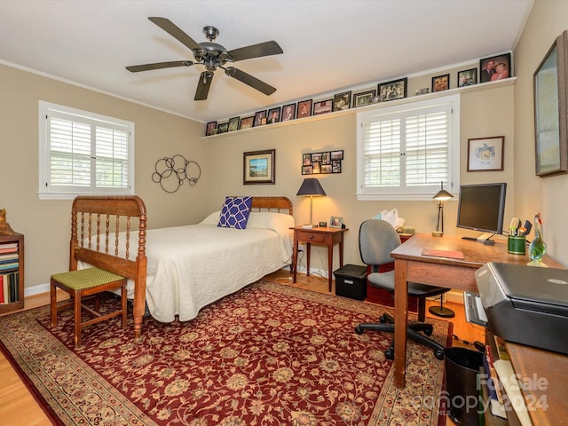 bedroom with multiple windows, ceiling fan, hardwood / wood-style floors, and ornamental molding