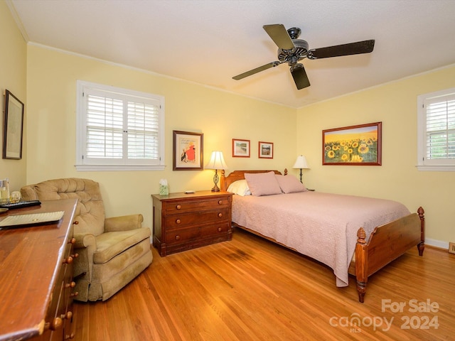 bedroom featuring ceiling fan, light hardwood / wood-style floors, and ornamental molding