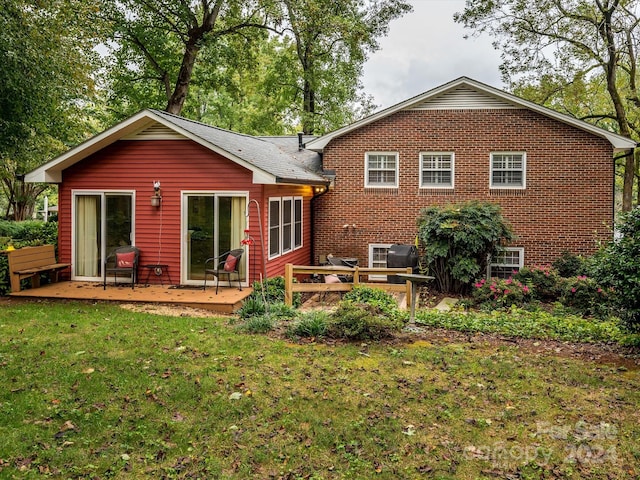 back of house featuring a lawn and a deck