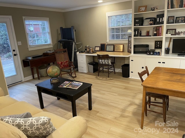 living room featuring a healthy amount of sunlight, built in desk, light hardwood / wood-style floors, and ornamental molding