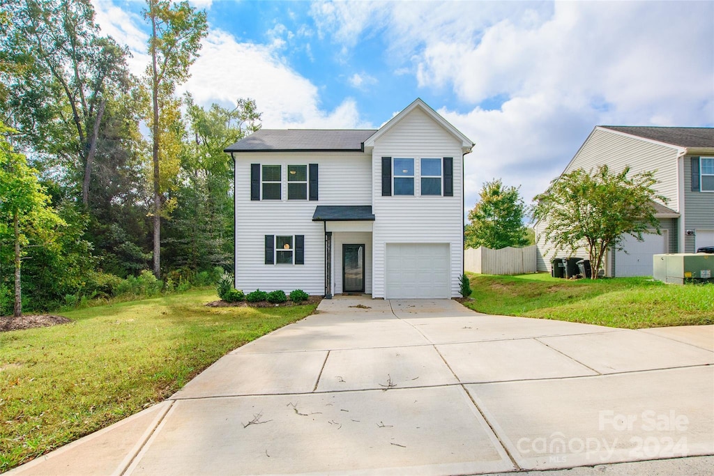 view of property featuring a front lawn and a garage