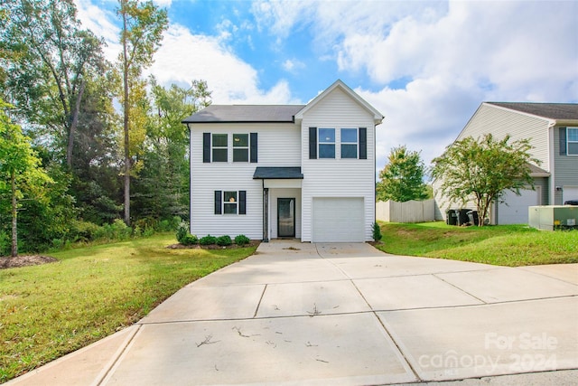 view of property featuring a front lawn and a garage