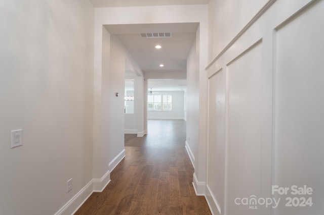 corridor with dark hardwood / wood-style flooring