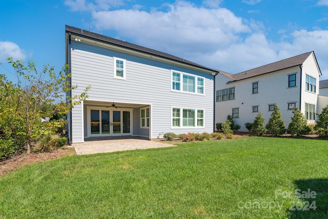 back of property with a lawn, ceiling fan, and a patio area