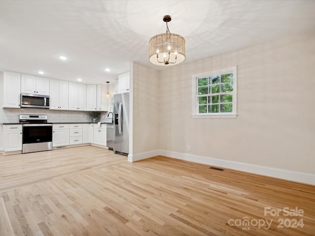 kitchen featuring a notable chandelier, white cabinetry, light hardwood / wood-style flooring, stainless steel appliances, and decorative light fixtures