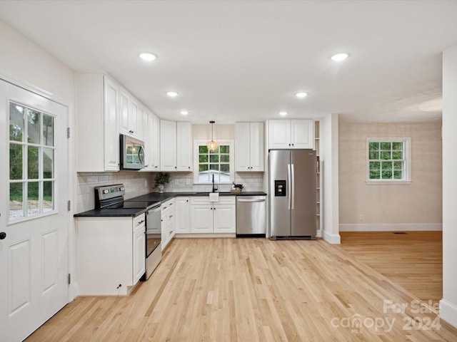 kitchen featuring white cabinets, stainless steel appliances, and light hardwood / wood-style flooring