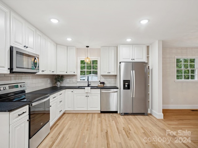 kitchen featuring stainless steel appliances, light wood-type flooring, sink, and white cabinetry