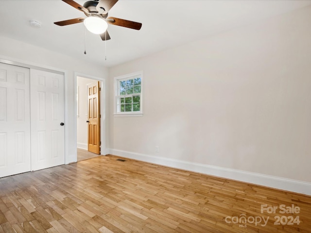 unfurnished bedroom with ceiling fan, light hardwood / wood-style flooring, and a closet