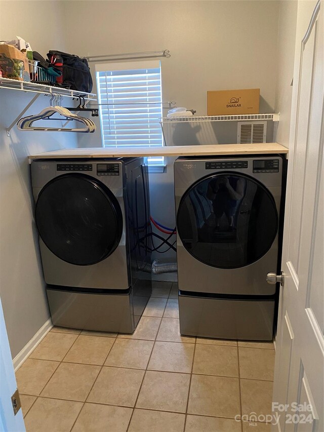 clothes washing area with light tile patterned floors and washing machine and dryer