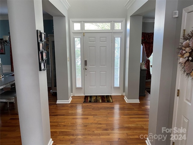 entryway featuring crown molding and hardwood / wood-style floors