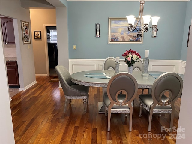 dining space featuring an inviting chandelier, dark hardwood / wood-style floors, and washer / dryer