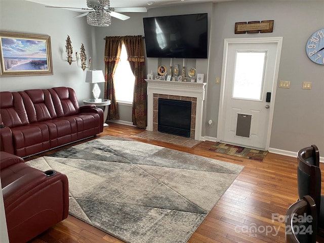 living room featuring wood-type flooring, a fireplace, and ceiling fan