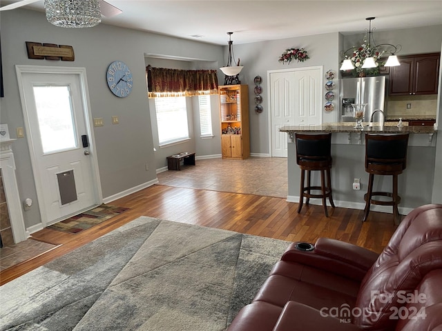 living room with an inviting chandelier, dark hardwood / wood-style floors, and sink