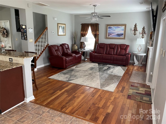 living room with ceiling fan and dark hardwood / wood-style flooring