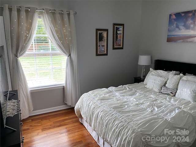 bedroom featuring hardwood / wood-style flooring and multiple windows