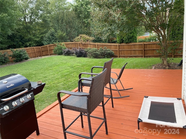 wooden terrace with a yard and a grill