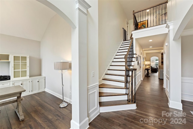 staircase with hardwood / wood-style floors and a high ceiling