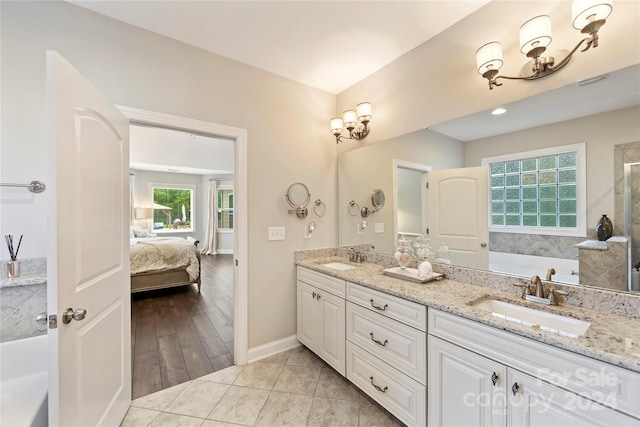 bathroom with vanity, a tub, and wood-type flooring