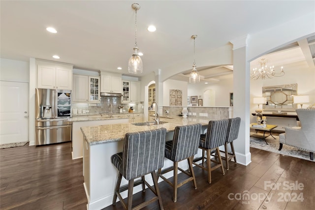 kitchen featuring white cabinetry, stainless steel refrigerator with ice dispenser, backsplash, and dark hardwood / wood-style flooring