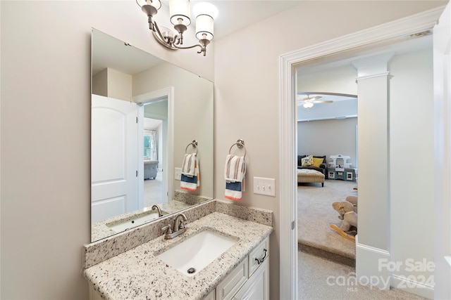 bathroom featuring vanity and ceiling fan with notable chandelier