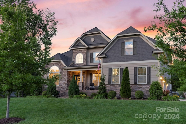 craftsman-style house with covered porch and a yard