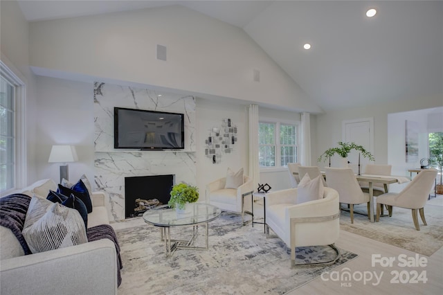 living room with a fireplace and high vaulted ceiling