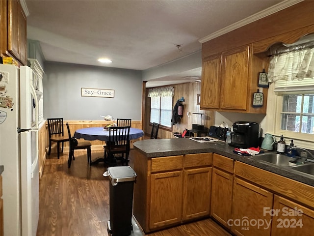 kitchen with kitchen peninsula, ornamental molding, dark wood-type flooring, and white fridge