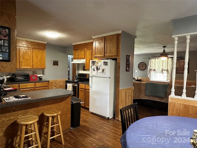 kitchen with stainless steel electric stove, dark wood-type flooring, a breakfast bar, white refrigerator, and ceiling fan