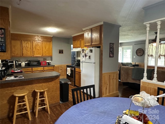 interior space with stainless steel electric stove, dark wood-type flooring, white fridge, a textured ceiling, and decorative columns