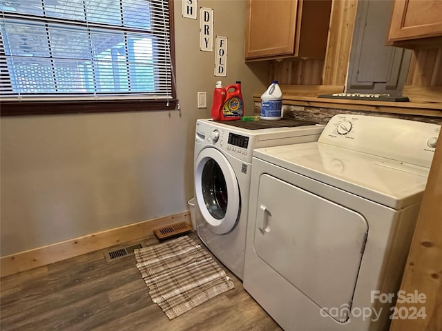 laundry room with cabinets, hardwood / wood-style flooring, and washer and clothes dryer