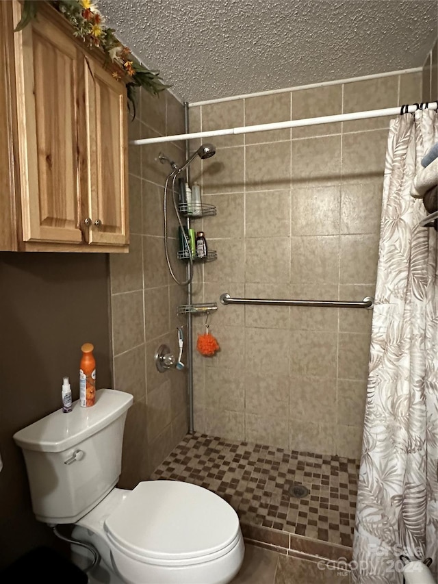 bathroom featuring a textured ceiling, toilet, and curtained shower