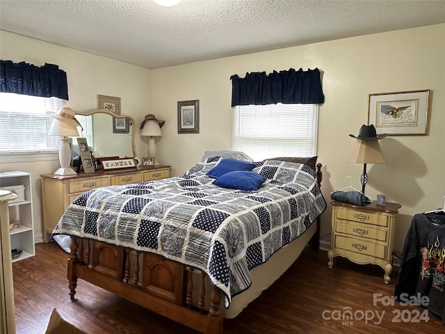 bedroom featuring a textured ceiling and dark hardwood / wood-style floors