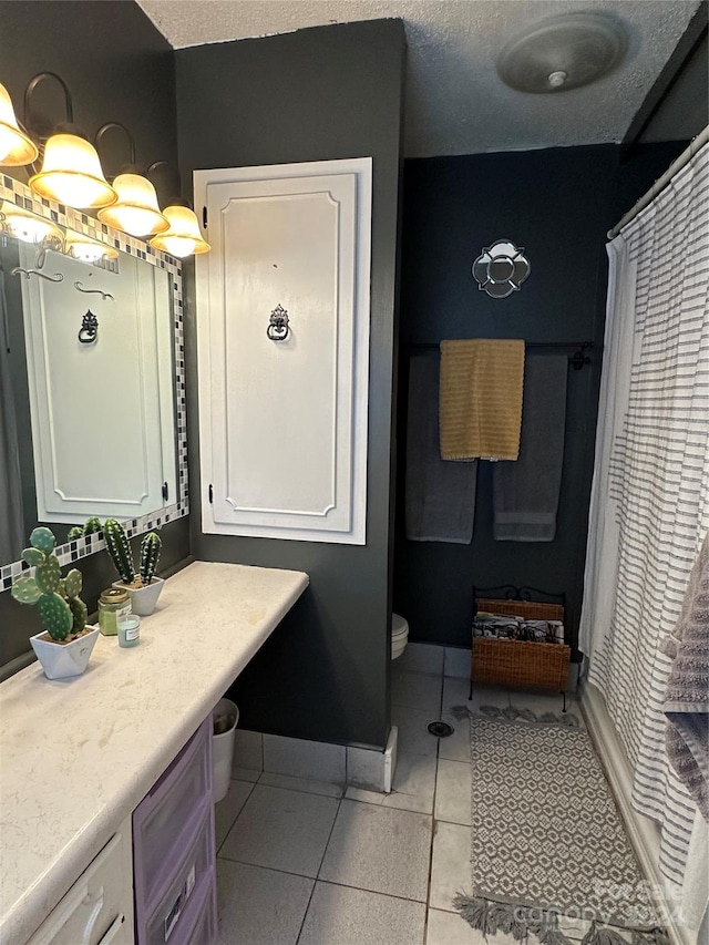 bathroom featuring tile patterned flooring, a textured ceiling, a shower with curtain, vanity, and toilet