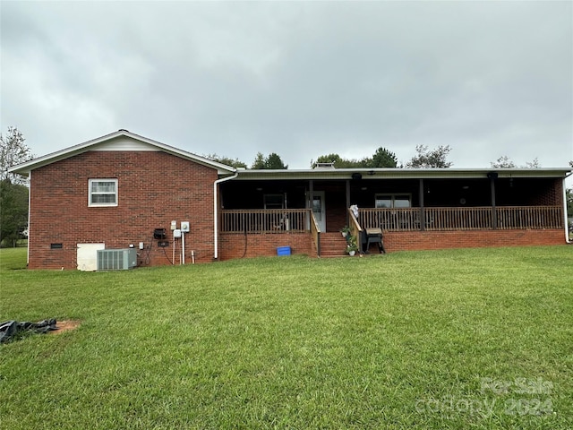 back of house featuring a lawn and central air condition unit