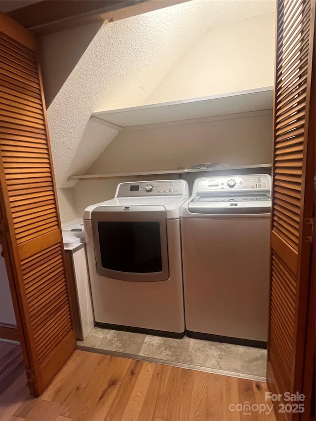 washroom with independent washer and dryer and light wood-type flooring