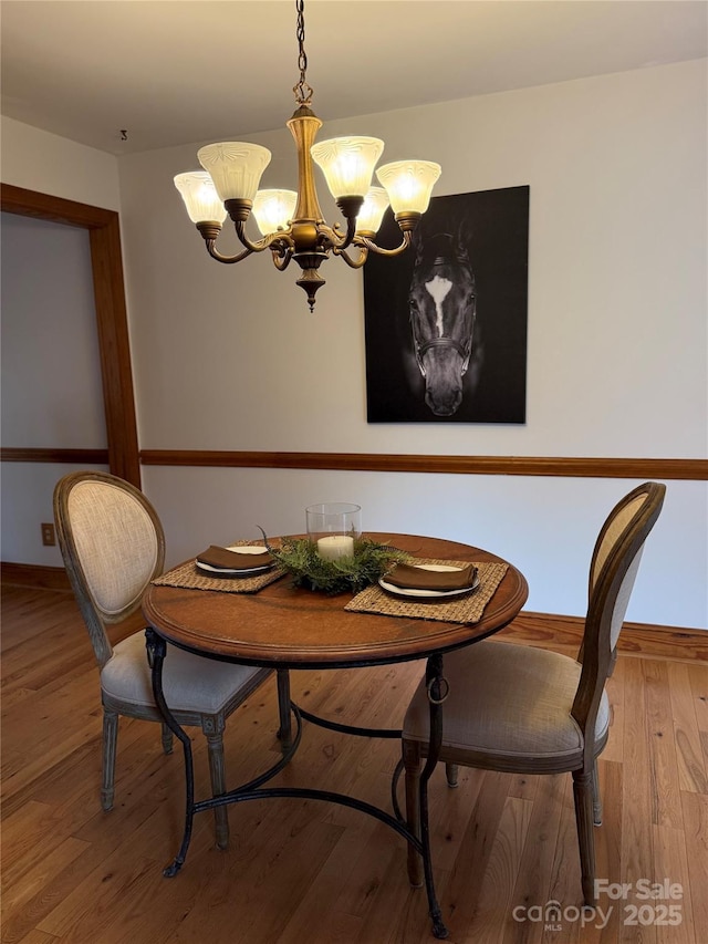 dining area with an inviting chandelier and hardwood / wood-style flooring